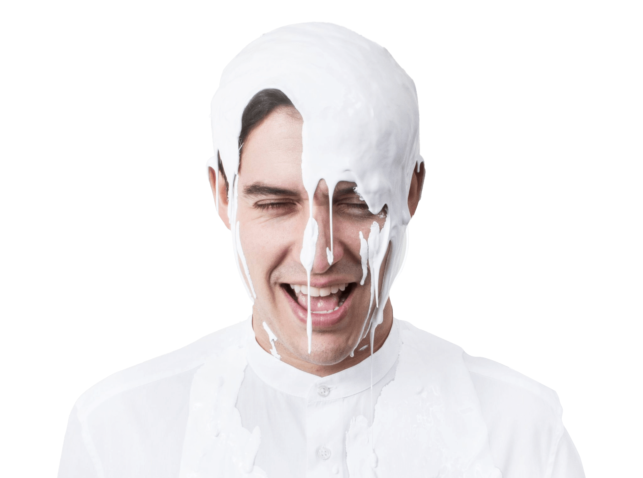 Esteban dressed in white, smiling and looking down with white paint on his head.